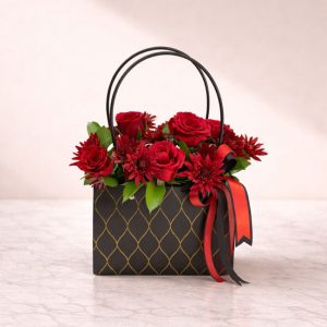 A unique handbag-shaped gift box featuring 5 fresh red roses beautifully arranged with delicate red chrysanthemum flowers